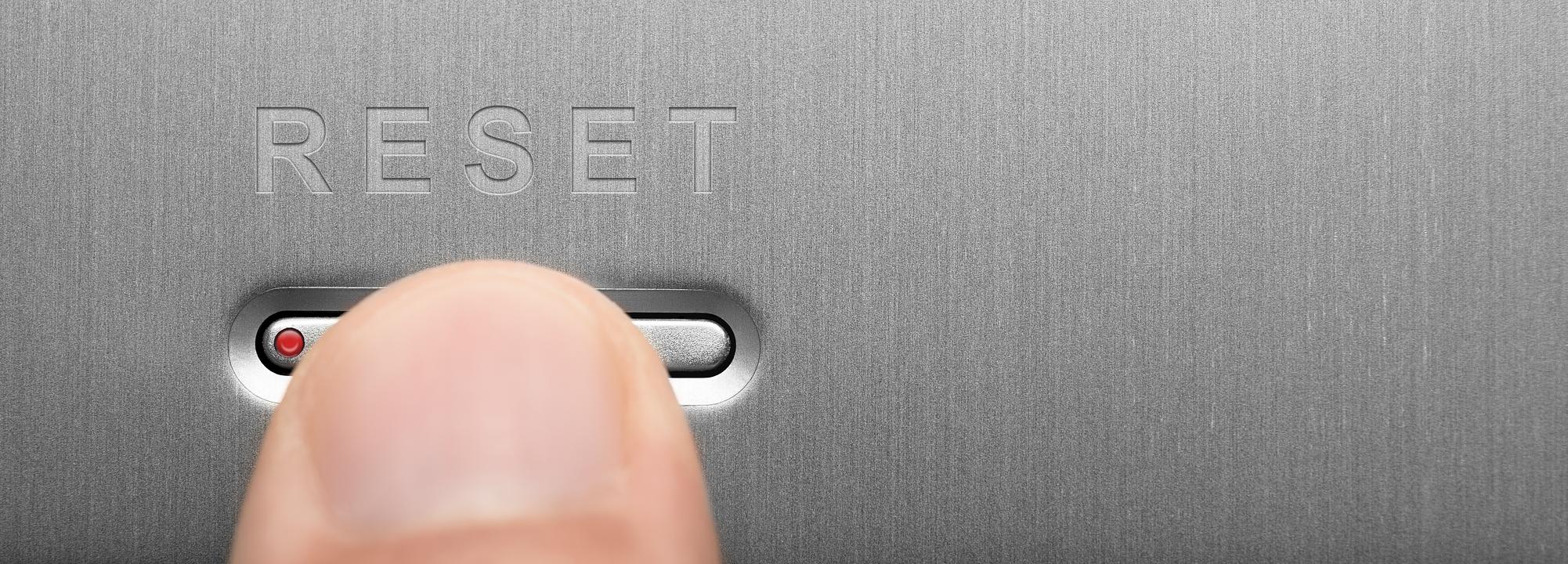 A finger on a "Reset" button