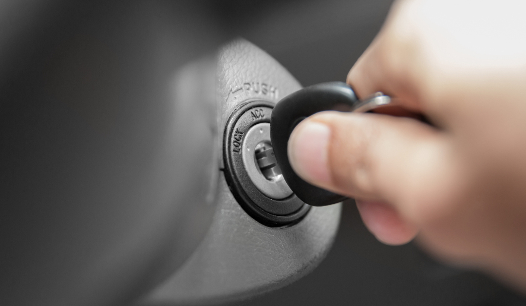 A hand turning the key in a car