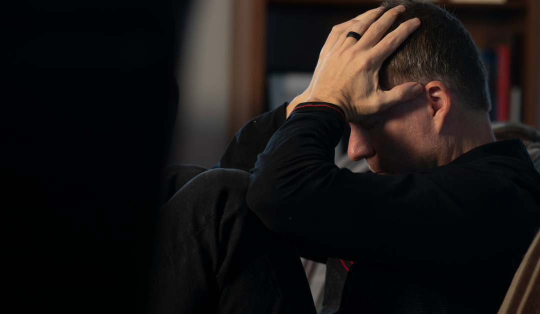 A frustrated man, sitting with his head in his hands