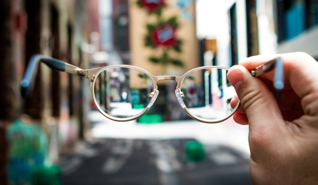 photo looking at and through glasses at a blurry scene beyond